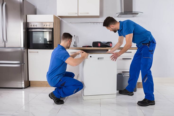 Appliance technician repairing a refrigerator